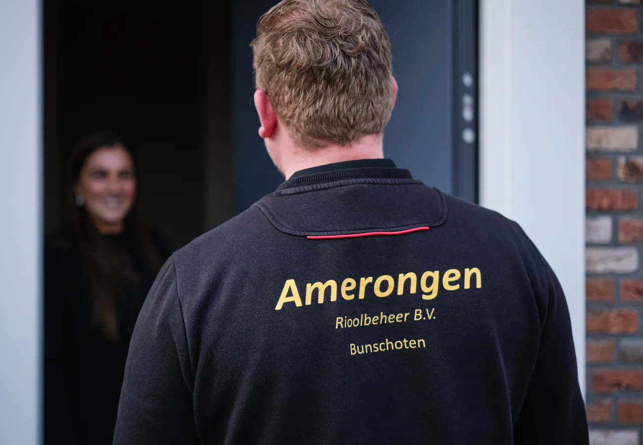 Monteur van Amerongen Rioolbeheer wordt bij aankomst hartelijk ontvangen door een klant aan de voordeur