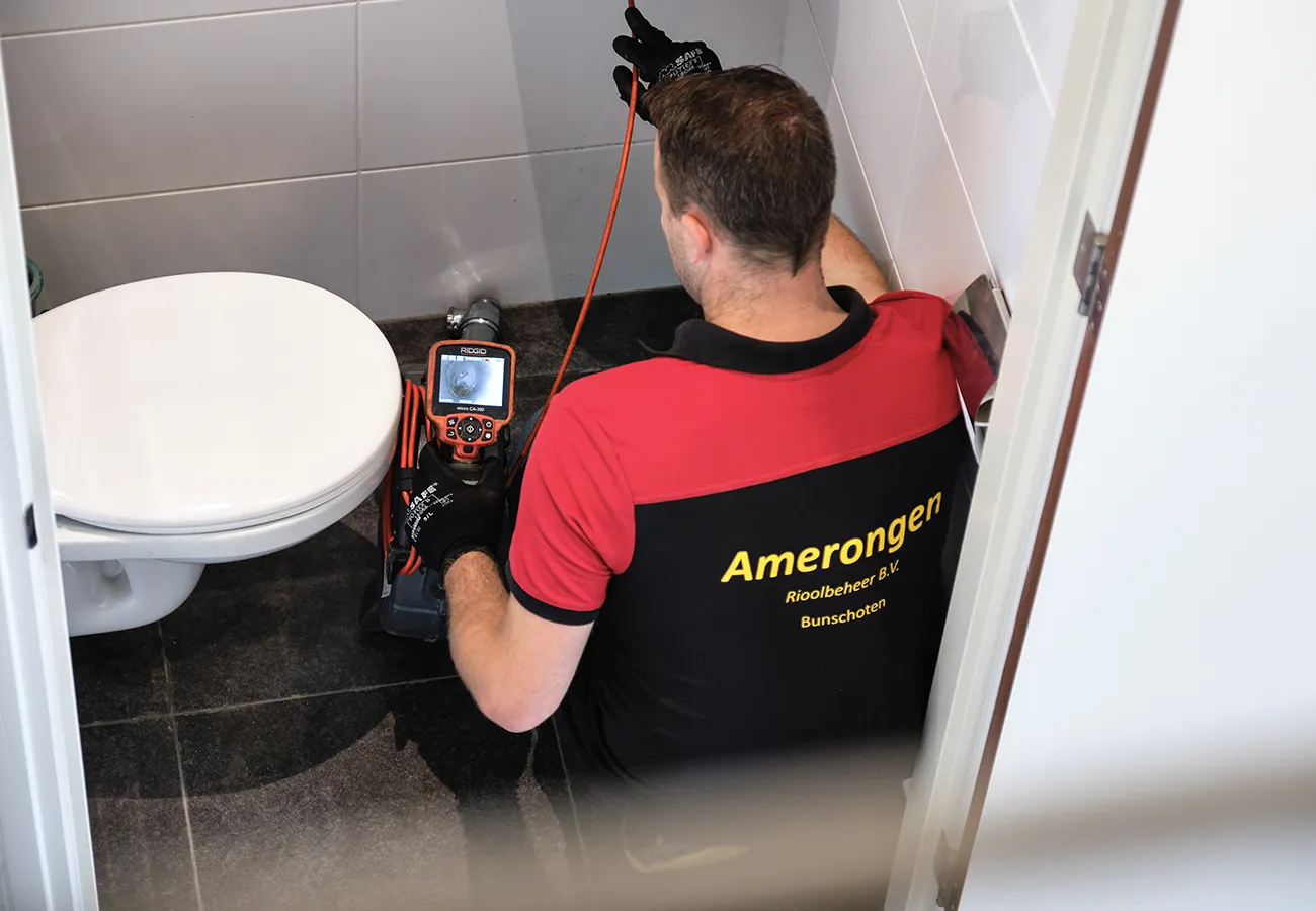 Monteur van Amerongen Rioolbeheer inspecteert een verstopt toilet met een camera