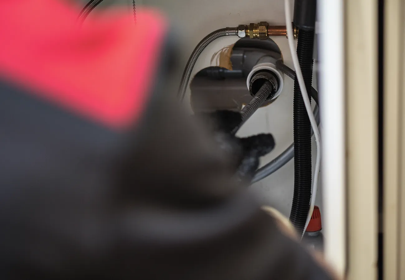 Monteur van Amerongen Rioolbeheer controleert de afvoerslang van een vaatwasser