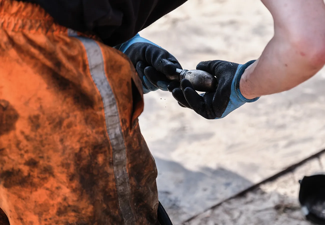 Medewerker van Amerongen Rioolbeheer aan het werk met gereedschap tijdens onderhoud