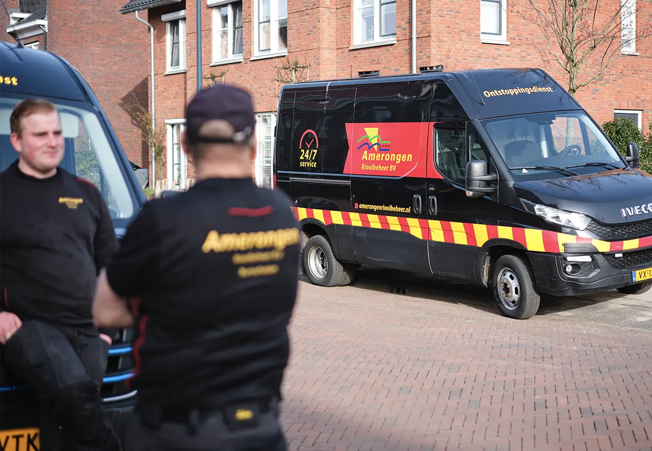 Medewerkers van Amerongen Rioolbeheer met de bedrijfsbus bij een woning